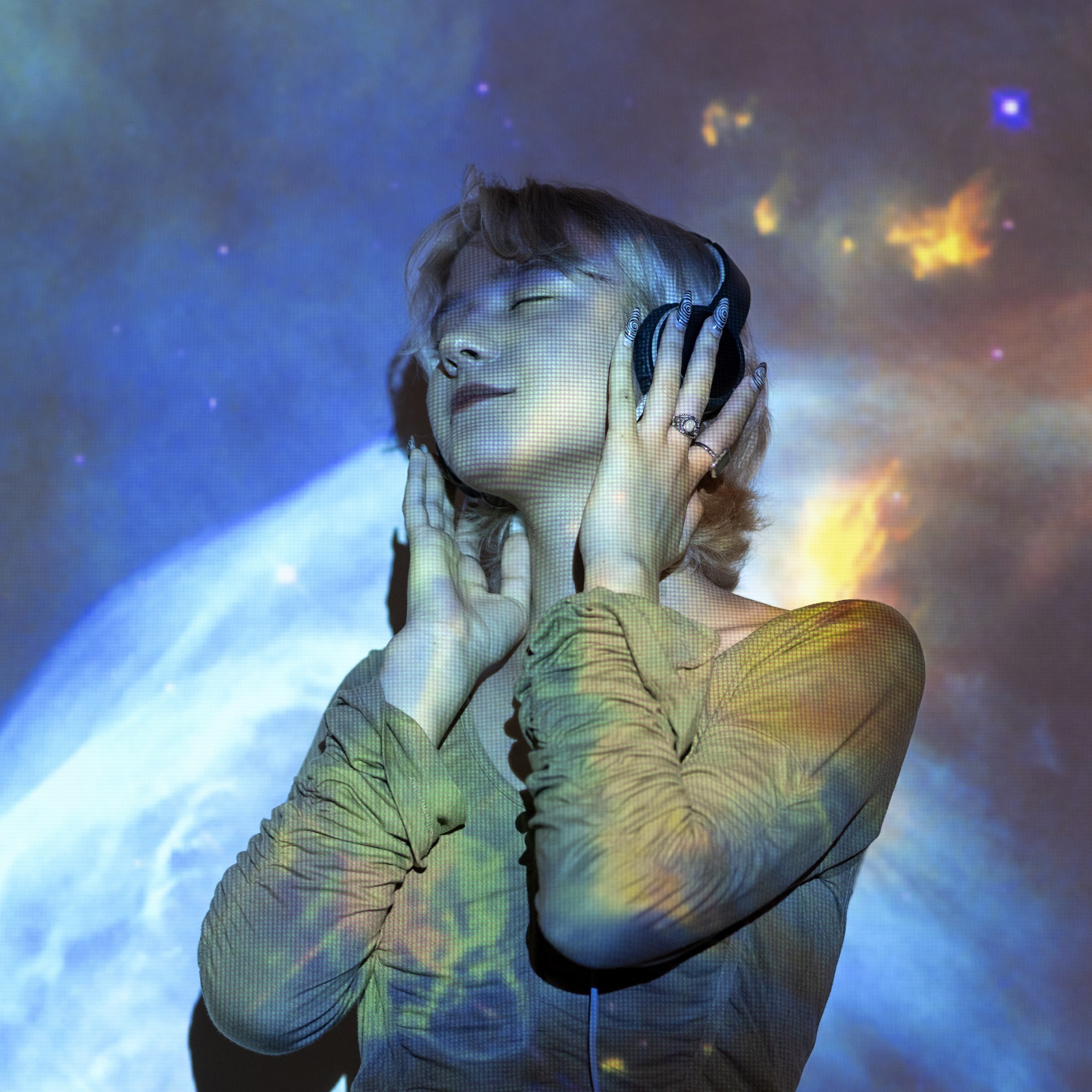Woman with headphones bathed in cosmic light, eyes closed in blissful resonance, symbolizing the energetic connection of sound and self.