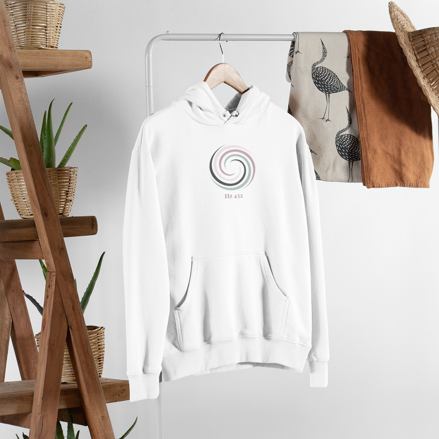 Aura Spiral Hoodie in Halo White hanging on wooden rack — minimalist spiritual apparel with Hz 432 print by Soft Frequencies™