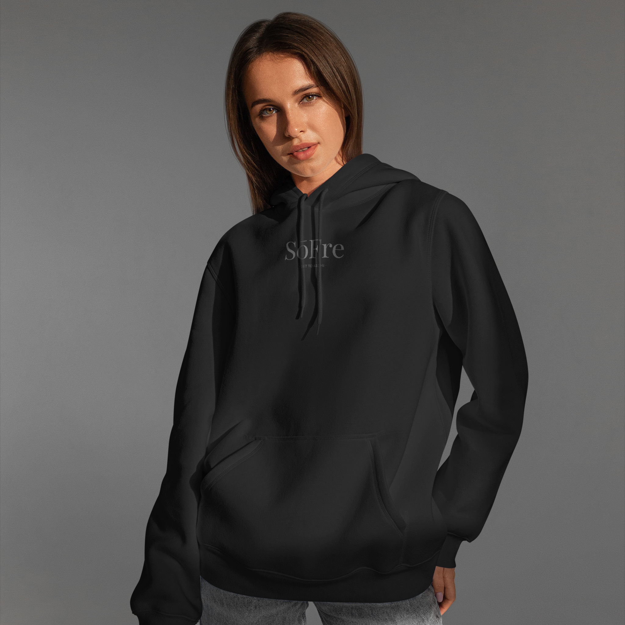 Women in Sofre wearing a black hoodie with a logo on a gray background